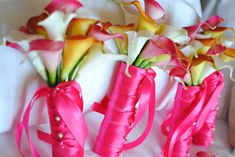 pink and white flowers in vases with ribbons