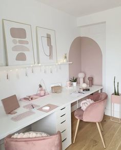 a white desk topped with pink chairs next to a wall mounted art work area and potted plants