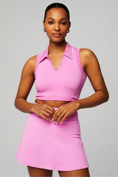 a woman in a pink dress posing for the camera with her hands on her hips