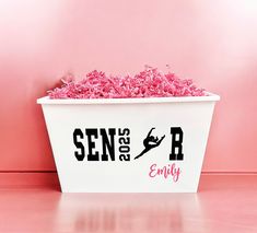 a white tub filled with pink shredded paper on top of a pink floor next to a wall