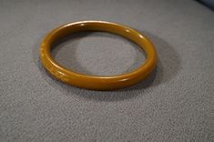 I am offering you this wonderful vintage Bakelite fancy carved, dark colored butterscotch colored Bakelite bangle bracelet (tested positive) It is very dimensional domed, and detailed. There is such intense color saturation to this Bakelite. It is bold and very curvaceous and convex measuring 2 1/2 inches in diameter, and it is a bit under 1/2 inch wide. It has very rounded and curved edges, you will be noticed when wearing this beauty!! The plastics are so popular with Lucite, Bakelite, and cel Formal Brown Round Bangle, Vintage Brown Carved Bracelets, Vintage Carved Brown Bracelets, Handmade Round Bakelite Jewelry, Brown Bakelite Jewelry Gift, Brown Bakelite Bangle Bracelet, Elegant Bakelite Bracelet, Retro Round Bakelite Jewelry, Vintage Orange Bangle Bracelets