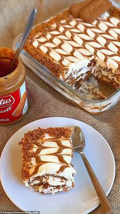 a piece of cake sitting on top of a white plate next to a jar of peanut butter