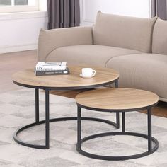 two coffee tables sitting on top of a rug in front of a couch and table