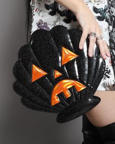 Whether you're happy as a clam or not, the Scallop-O-Lantern crossbody bag will add a little sparkle to your day! These double sided sculptural bags are made with rainbow black glitter and holographic orange vegan PU leather. Our zip top bag features a fully lined interior with side and zip pockets. The outside of bag measures 12"x12"x4" with compartment size of 9x"9"x4". Made of Vegan PU leather Cool Bags, Pretty Snakes, Happy As A Clam, Unique Backpacks, Accesories Jewelry, Disney Handbags, Formal Pants, Goth Girl, Novelty Bags