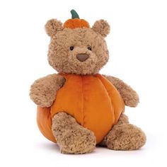 a brown teddy bear sitting on top of a pumpkin