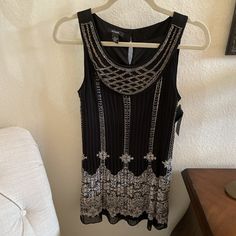 Nwt Alfani Sleeveless Shirt. Beautiful! Size 6. Beaded With Dark Bronze Beads, Pleated And Very Flattering Style! Black With Grey Pattern, Attached Black Camisole. Two Button Closure In Back At Neck Line. 100% Polyester. A Row Of Three Beads Is Missing And One Row Has Some Loose Beads, But I Didn't Notice Until I Took The Close-Up Pic. Extra Button Included In Little Pouch By Price Tag. Black Sleeveless Embellished Tops, Black Embellished Sleeveless Tops, Elegant Beaded Tank Top, Black Camisole, Grey Pattern, Sleeveless Shirt, Price Tag, Loose Beads, Black Gray