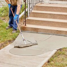 a man is using a mop to clean the concrete on the steps outside his house