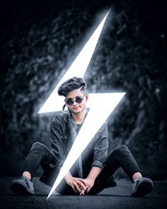 a young man sitting on the ground with a lightning bolt in his hand and wearing sunglasses