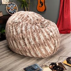 a bean bag chair sitting on top of a hard wood floor next to a guitar