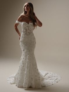 a woman in a wedding dress posing for the camera with her hands on her head