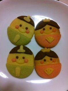 four decorated cookies sitting on top of a white plate