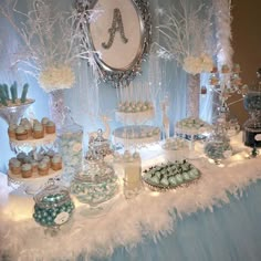 a dessert table filled with cupcakes, cookies and other treats on top of it