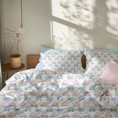 an unmade bed with blue and pink sheets