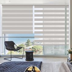 the bedroom is decorated in shades of grey and white, with an open window overlooking the ocean