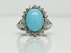 A classic and timeless design, a 13x9mm oval Turquoise cabochon with 26d weighing 0.46ctw H/SI1, Respectively. Luxury Turquoise Oval Cabochon Ring, Classic Turquoise Ring For Formal Occasions, Classic Formal Turquoise Ring, Elegant Oval Cabochon Turquoise Ring For Formal Occasions, Elegant Oval Cabochon Turquoise Ring For Formal Events, Formal Oval Cabochon Turquoise Ring, Luxury Blue Oval Cabochon Turquoise Ring, Classic Oval Turquoise Ring For Formal Occasions, Turquoise Oval Cabochon Ring With Polished Finish