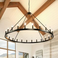 a large chandelier hanging from the ceiling in a living room with wood beams