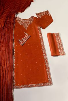 Meticulously crafted from a remarkably glamourous shade of burnt orange ( pure raw silk 60 gms )“ Minaree “ with its intricate zari details strikes the perfect balance between elegant and eye-catching, making this beautiful design a must have. The length of the long kameez is 46 inches.Agha Noor’s style tip - “ Style w Formal Red Salwar Kameez With Intricate Embroidery, Red Embroidered Salwar Kameez For Formal Occasions, Formal Red Embroidered Salwar Kameez, Elegant Long Dress With Cutdana, Elegant Red Salwar Kameez With Resham Embroidery, Elegant Red Unstitched Suit With Intricate Embroidery, Elegant Red Salwar Kameez With Dabka, Elegant Unstitched Red Salwar Kameez, Elegant Embroidered Katan Silk Set