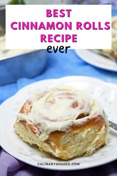 the best cinnamon rolls recipe ever on a white plate with a blue tablecloth and purple cloth