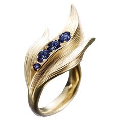 This contemporary Lily of The Valley Ring is made of 18 karat yellow gold and 4 round blue sapphires. It has a sculptural shape. We work with German gems companies that have been in business since the 19th century. The ring can be personalised with a name or a saying. Please allow us time to customize the ring. The ring can be ordered as usual fashion ring. The size and the colour of the gold can be changed. Round Sculpture, Magic Items, Ring With Diamond, Shiny Things, Fashion Ring, Contemporary Jewellery, Lily Of The Valley, Jewelry Rings Engagement, The Valley