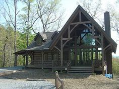 a large log cabin sits in the woods