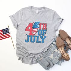 the fourth of july t - shirt is next to an american flag and some jeans