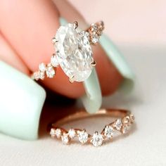 a close up of a person's hand with an engagement ring and wedding band