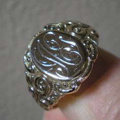 Such a beautiful ring for they guys but could be sized down for the ladies, within reason. This ring has fabulous scroll detailing on the shoulders. The oval face area is approx. 5/8 inches long and under 1/2 inch wide. Marks are the back 10 k and tested as such. Ring is heavy at 8.8 grams and approx. a size 13. This ring has been size up in the past. You can feel a slight ripple in the band in back as well as it being a bit thinner. Not an issue but an observation. The initials on the face look Victorian Oval Signet Ring With Polished Finish, Victorian Yellow Gold Engraved Ring With Polished Finish, Victorian 14k Gold Signet Ring With Polished Finish, Formal White Gold Jewelry With Initials, Victorian Engraved Ring With Polished Finish In 14k Gold, Victorian Engraved Signet Promise Ring, Victorian Yellow Gold Rings With Engraving Option, Antique Engraved Ring With Polished Finish For Formal Occasions, Victorian 14k Gold Engraved Ring With Polished Finish