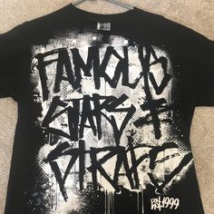 New Famous T-Shirt Sz Medium Black Hip Hop T-shirt With Graffiti Print, Black Hip Hop Top With Graffiti Print, Black Urban Tops For Fan Merch, Black Urban Top For Fan Merchandise, Black Band Merch T-shirt With Graffiti Print, Black T-shirt With Graffiti Print Band Merch, Black T-shirt With Graffiti Print For Fan Merchandise, Black Hip Hop Shirt With Letter Print, Black Graffiti Print T-shirt For Fans