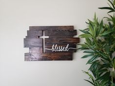 a wooden sign with the word bliss on it next to a potted green plant