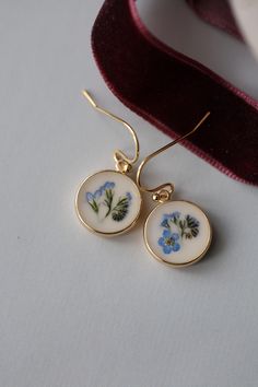 Botanical earrings made from real dried flowers and clear resin. A wonderful gift for nature lovers. Details: Size in diameter: 1.2 cm (Let me know if you want other size ) Material: Clear resin, real forget me not flowers Metal: Gold plated brass Ready to ship **Your new earrings will arrive safely packaged in beautiful bag with our logo, complete with a card. A wonderful gift for you and your loved ones. Usually delivery takes 20-40 days depends on country, but please be aware that it could sometimes takes longer time, depends on the procedures at the custom of your country. In any case, I'll provide tracking number and you always can see where are your items. Full refund if items will not arrive in mentioned time (60 days). For more details please read Shipping&Policies and let me know Real Flower Earrings, Pressed Flower Earrings, Flower Earrings Gold, Forget Me Not Flowers, Pressed Flower Jewelry, Botanical Earrings, Queen Annes Lace, Funky Earrings, Lace Earrings