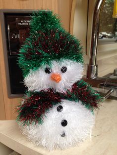 a snowman made out of tinsel on top of a counter next to a microwave