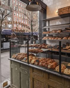 a bakery filled with lots of different types of breads and pastries on display