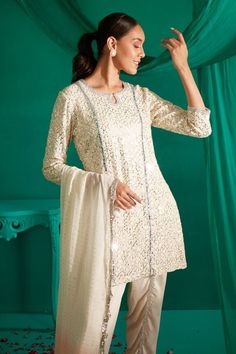 Ivory kurta with all over sequin, thread embroidery. Paired with a draped dhoti pant and peach dupatta. - Aza Fashions Elegant Gota Work Sets For Celebration, Festive Off-white Gota Work Sets, Festive Off White Straight Kurta Set, Festive Off White Sets With Straight Kurta, Festive Off-white Sets With Straight Kurta, Elegant Salwar Kameez With Gota Work For Celebration, Cream Kurta With Dupatta For Party, Elegant Chinon Churidar For Navratri, Off White Gota Work Sets For Diwali