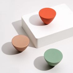 three different colored knobs sitting on top of a white surface with one red and one green