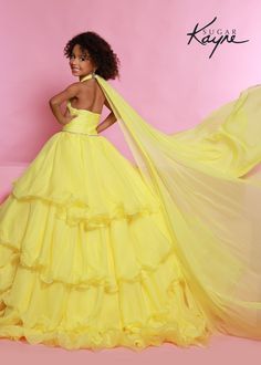 Sugar Kayne C305 Girls and Preteens Ruffle Pageant Ball Gown Cape Halter Formal DressOh s'cute!! This poly chiffon layered ballgown features a crisscross halter neckline with beaded trim along the waist. The train will float seamlessly across the stage, especially with the detachable cape. Oh s'cute!! This poly chiffon layered ballgown features a crisscross halter neckline with beaded trim along the waist. The train will float seamlessly across the stage, especially with the detachable cape.Colo Pageant Gown With Ruffles And Fitted Bodice, Quinceanera Pageant Ball Gown With Ruffles, Organza Ruffle Dress For Quinceanera, Yellow Ball Gown Dress For Debutante Ball, Yellow Ball Gown For Debutante Ball, Ruffled Ball Gown Dresses For Pageant, Ruffled Ball Gown Dresses For Pageants, Ruffled Ball Gown For Pageant, Pageant Organza Gown With Ruffles