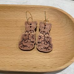 the wooden earrings are made to look like cats with flowers on their ears and paws