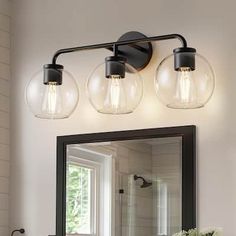 a bathroom vanity with three lights and a mirror