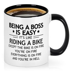 a black and white coffee mug that says being a boss is easy it's like riding a bike except the bike is on fire