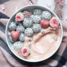 a bowl filled with fruit and flowers on top of a table