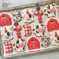 decorated cookies in the shape of farm animals and barnyards on a baking sheet