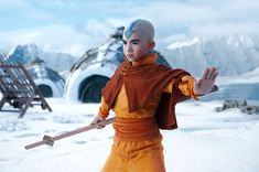 a young boy dressed as avatar from avatar in the snow with his arms out and hands outstretched