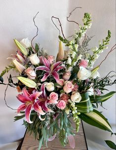 a vase filled with lots of pink and white flowers