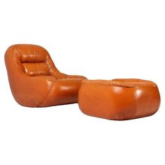 an orange leather lounge chair and ottoman with footstool in the shape of a reclining