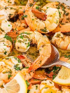 a pan filled with cooked shrimp and lemon wedges