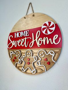 a wooden sign that says home sweet home with gingerbreads and candy canes