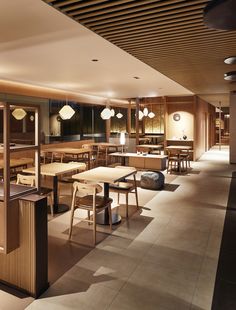 an empty restaurant with tables and stools in the center, lights hanging from the ceiling