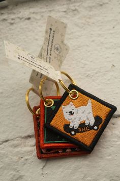 a keychain with a small white dog on it's front and back