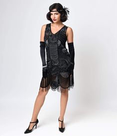 Get ready for an evening of cocktails and jazz in an outfit that epitomizes the romance of the 1920s. Unique Vintage’s The Bosley cocktail dress is an authentic replica of the beaded and fringed flapper frocks that made the Roaring ‘20s such an important time in fashion history, combined with a modern fit that is flattering on anyone’s unique figure. The shift shape hits just below the knees and features a V-neck bodice with slightly lower back, and its wide scalloped hemline is accented by bead 1920s Style Fitted Dress With Beaded Fringe, Fitted Beaded Fringe Flapper Dress For Costume Party, Embellished Fitted Flapper Dress For Costume Party, Fitted Flapper Dress With Beaded Fringe For Costume Party, Flapper Dress With Beaded Fringe For Night Out, Gatsby Style Summer Evening Flapper Dress, Night Out Flapper Dress With Beaded Fringe, Summer Gatsby Style Flapper Dress For Evening, Summer Evening Gatsby Flapper Dress