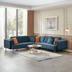 a living room with a blue couch and orange pillows on the corner table in front of it