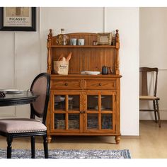 a dining room table with chairs and a hutch in the corner next to it